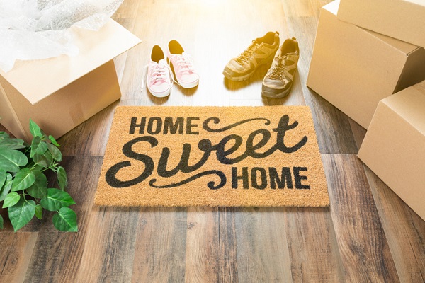 Move in day with a doormat saying home sweet home