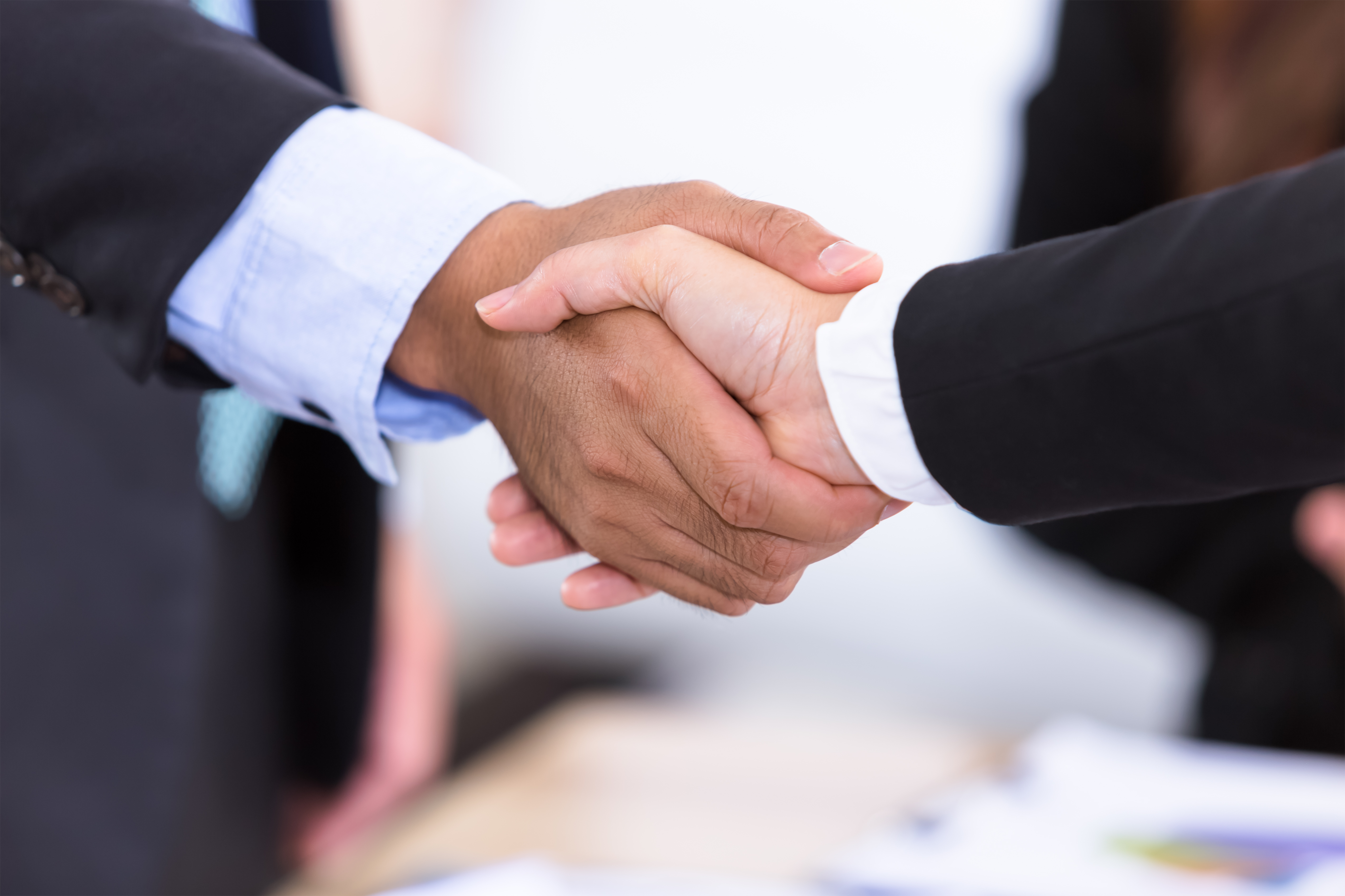 Male and female professionals shaking hands