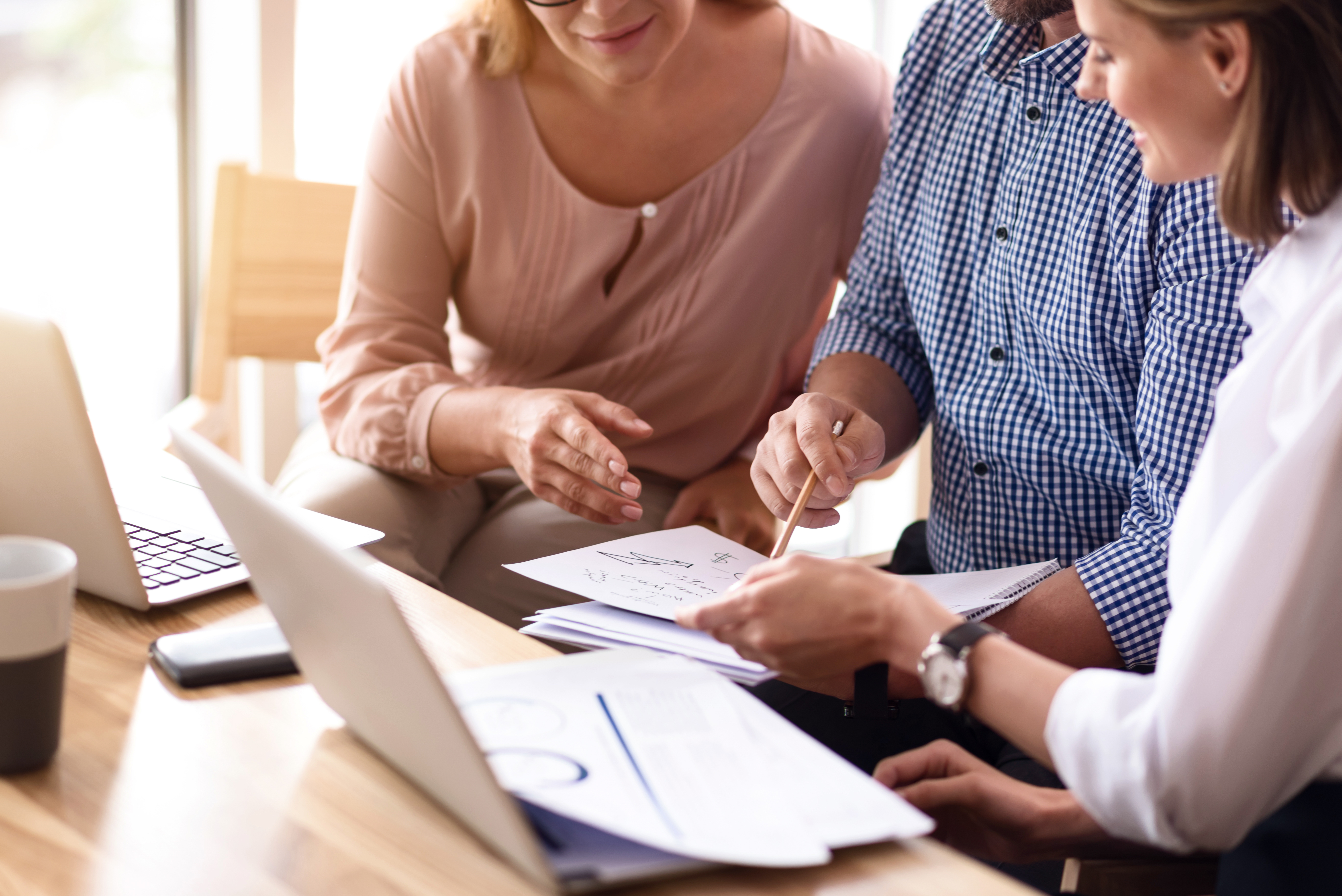banker and couple looking over financials at computer